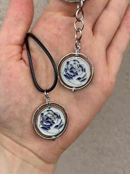 Interactive rotating spinner pendant necklace and keychain in pink and blue
