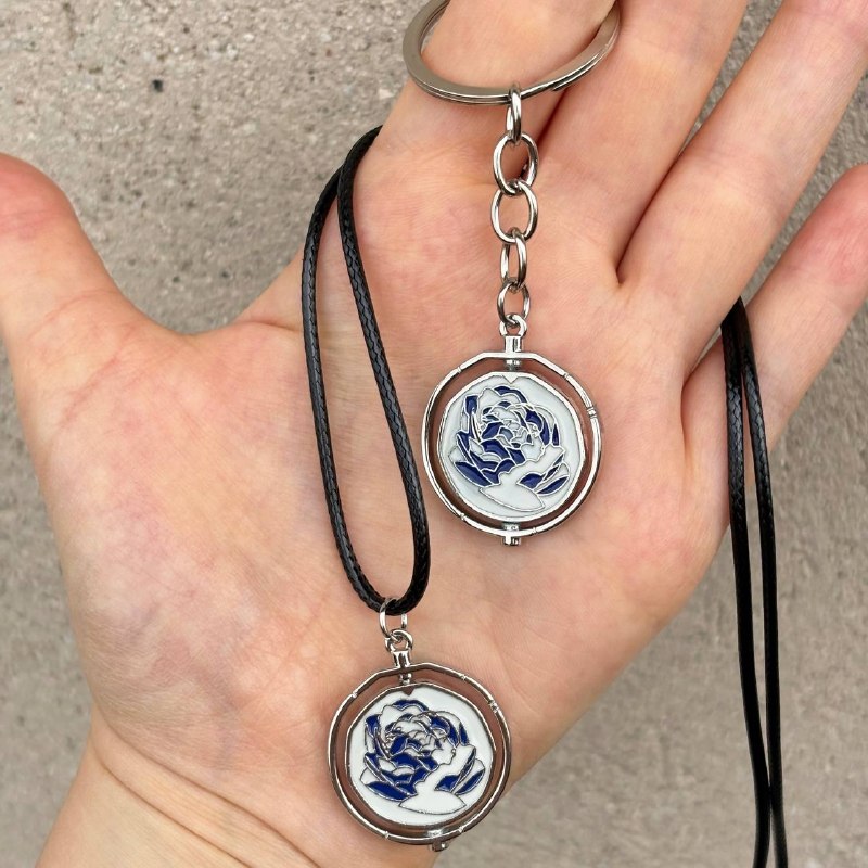 Interactive rotating spinner pendant necklace and keychain in pink and blue